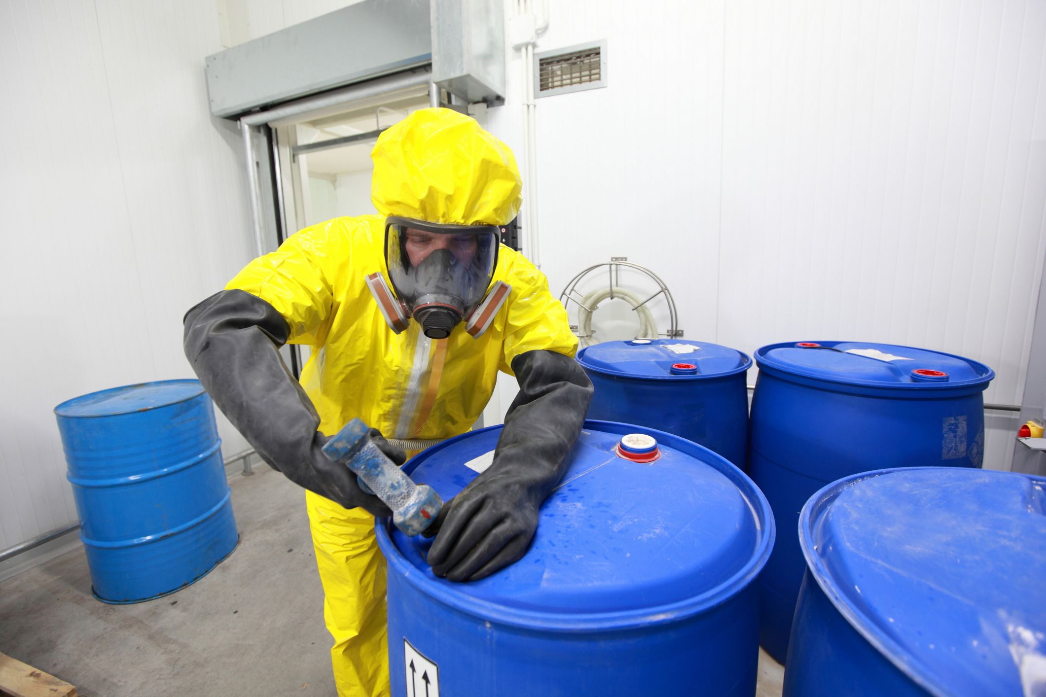 Alt-Text: Man spraying pesticides on a small shrub